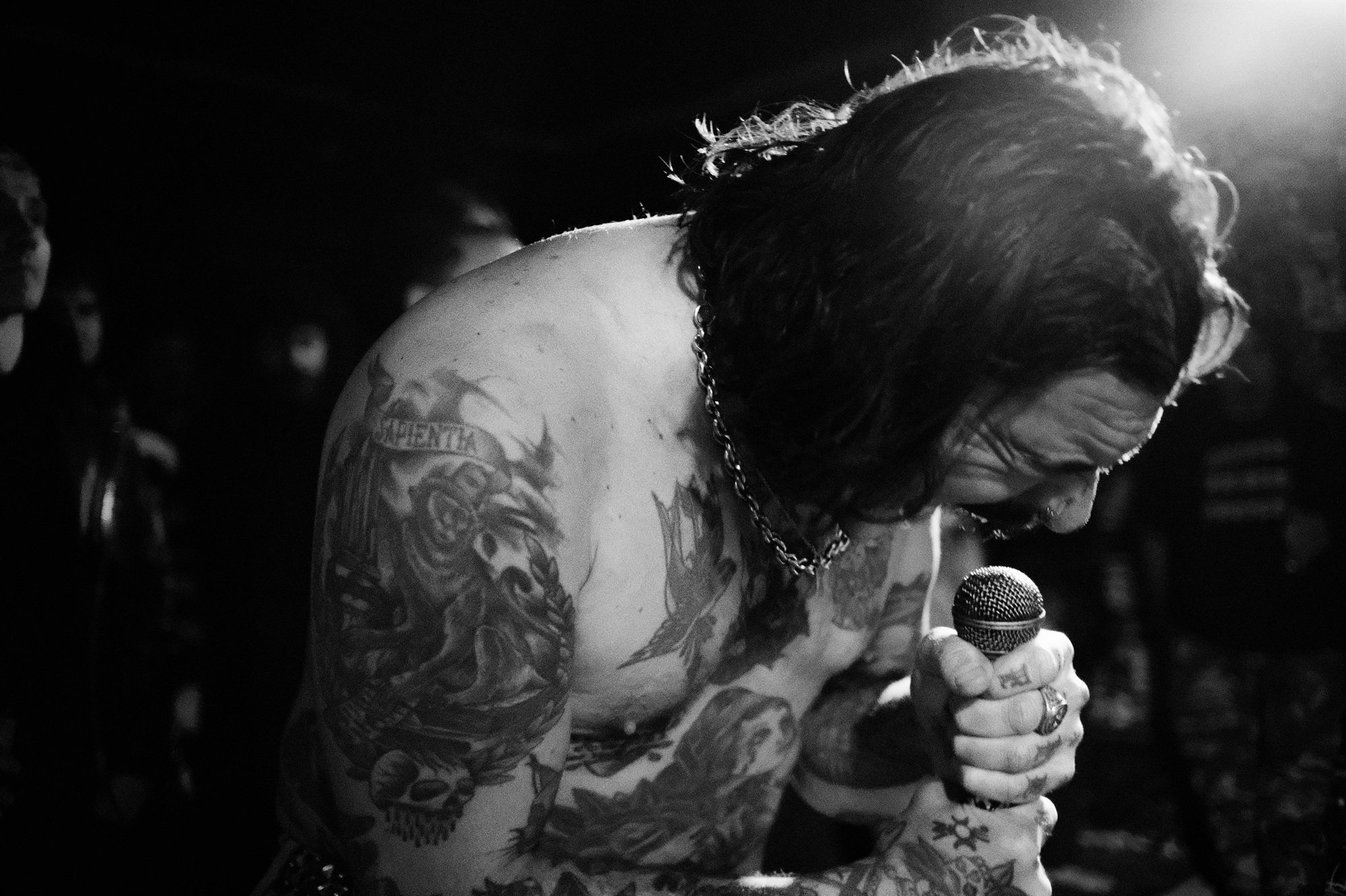 Cantante tatuado aferrado al micro, blanco y negro